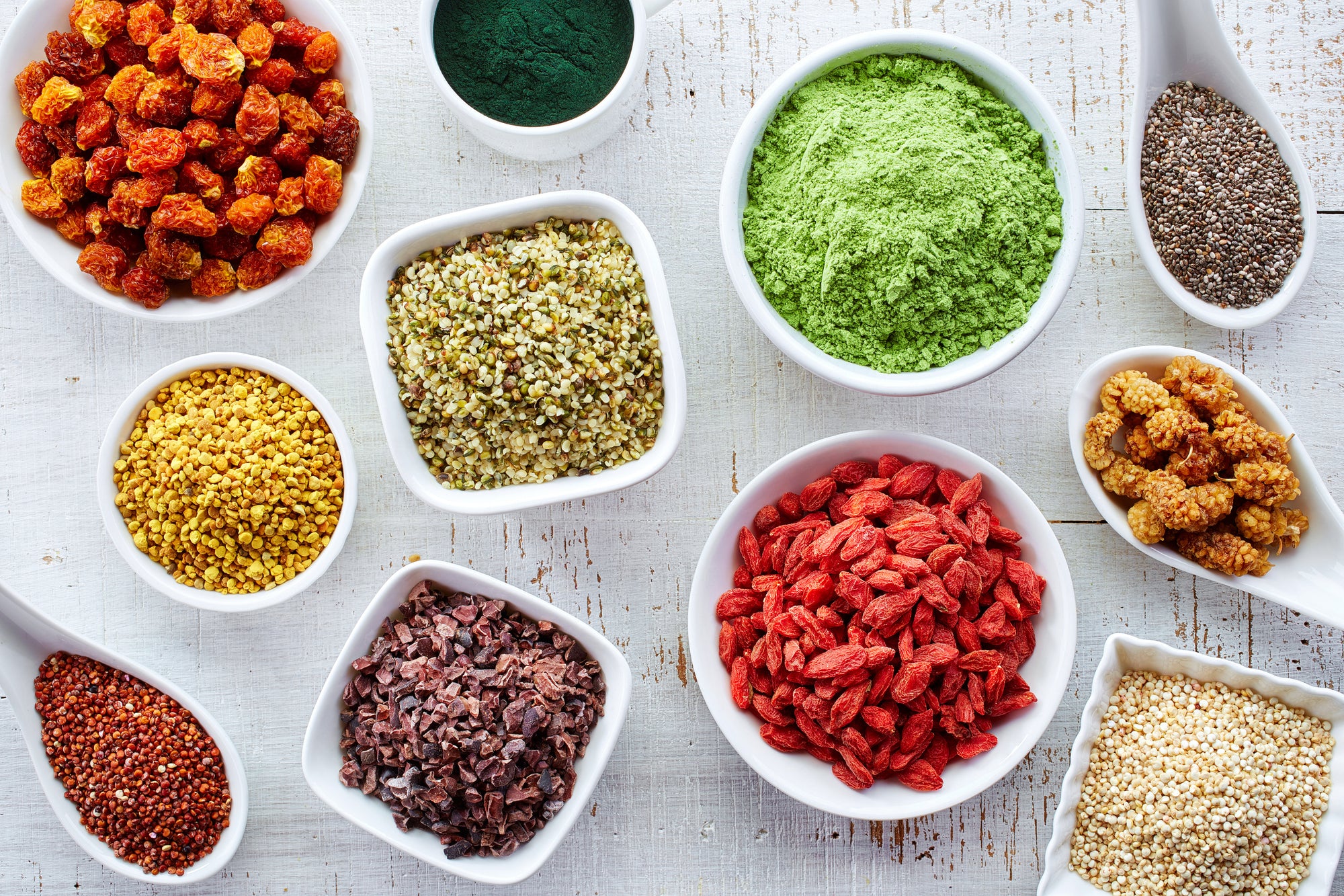 Various small bowls with dried fruit, seeds and powders