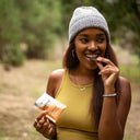 Young woman enjoying Defend Functional Chocolate in a park.
