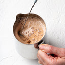 Blending a hot cacao elixir with a JOYÀ handheld rechargeable milk frother and blender.