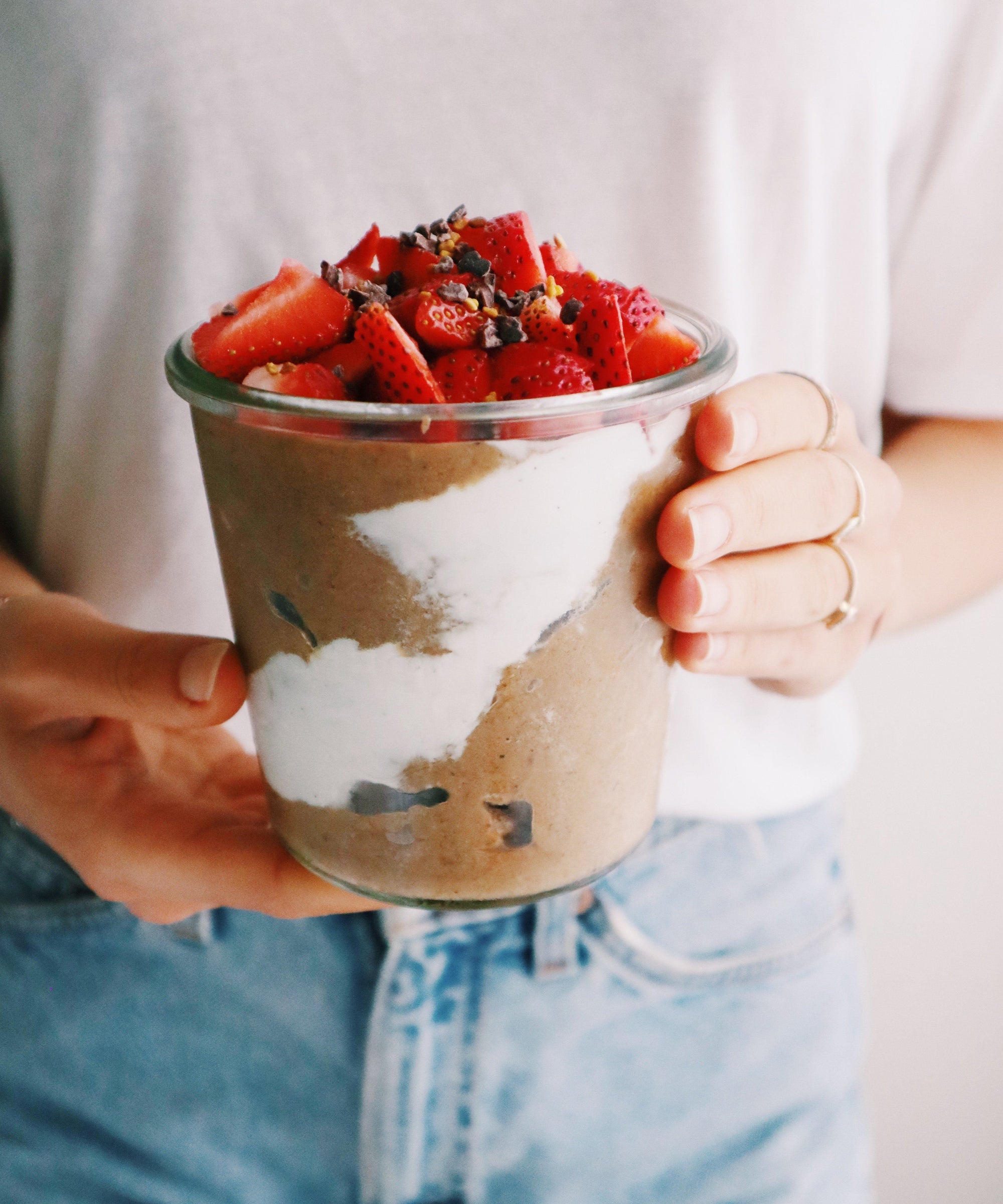 Hands holding big cup of JOYÀ Cacao Superfood Protein Smoothie. Recipe at joya.ca