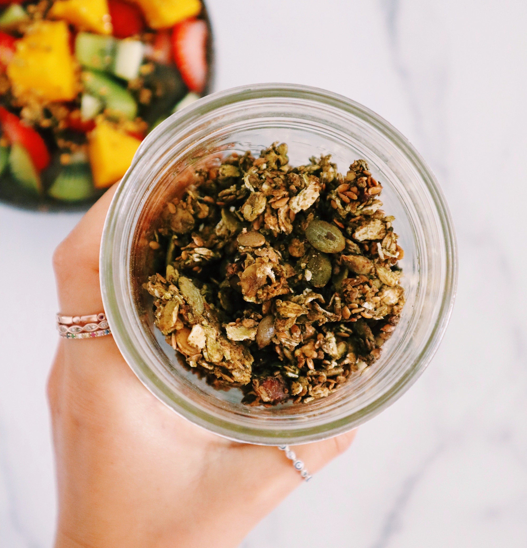 Hand holding jar of matcha granola made with JOYÀ Focus Elixir. Recipe at joya.ca