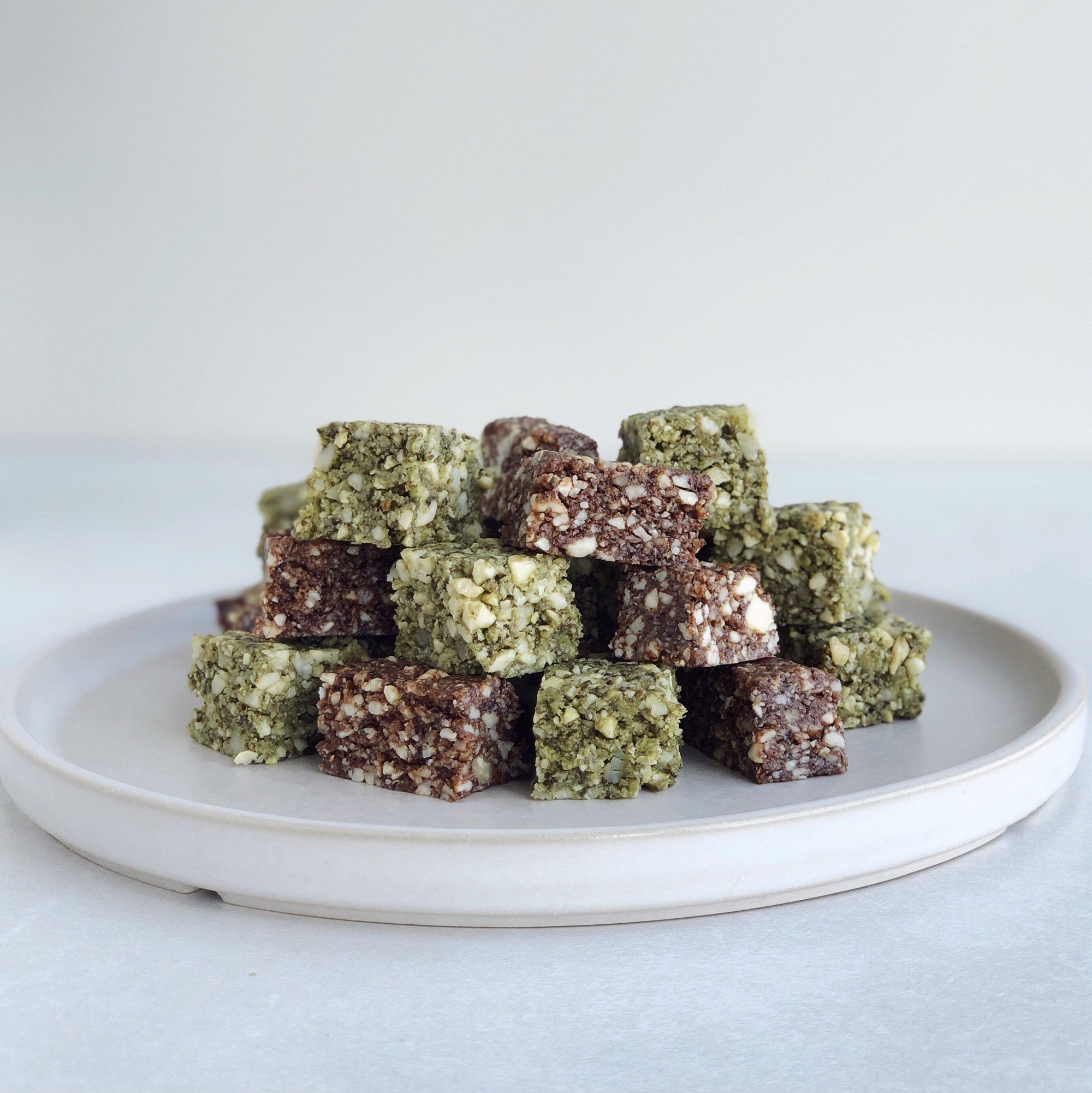 Plate of superfood bites featuring JOYÀ Matcha and Cacao elixirs