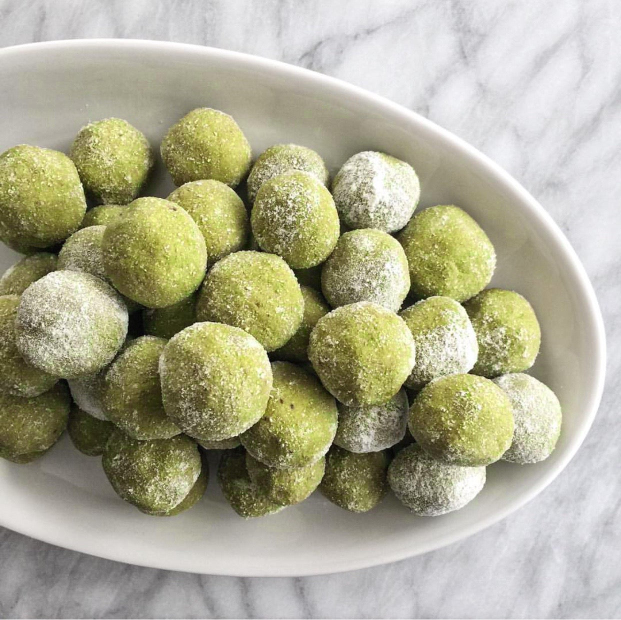 stack of coconut dusted matcha balls on marble counter