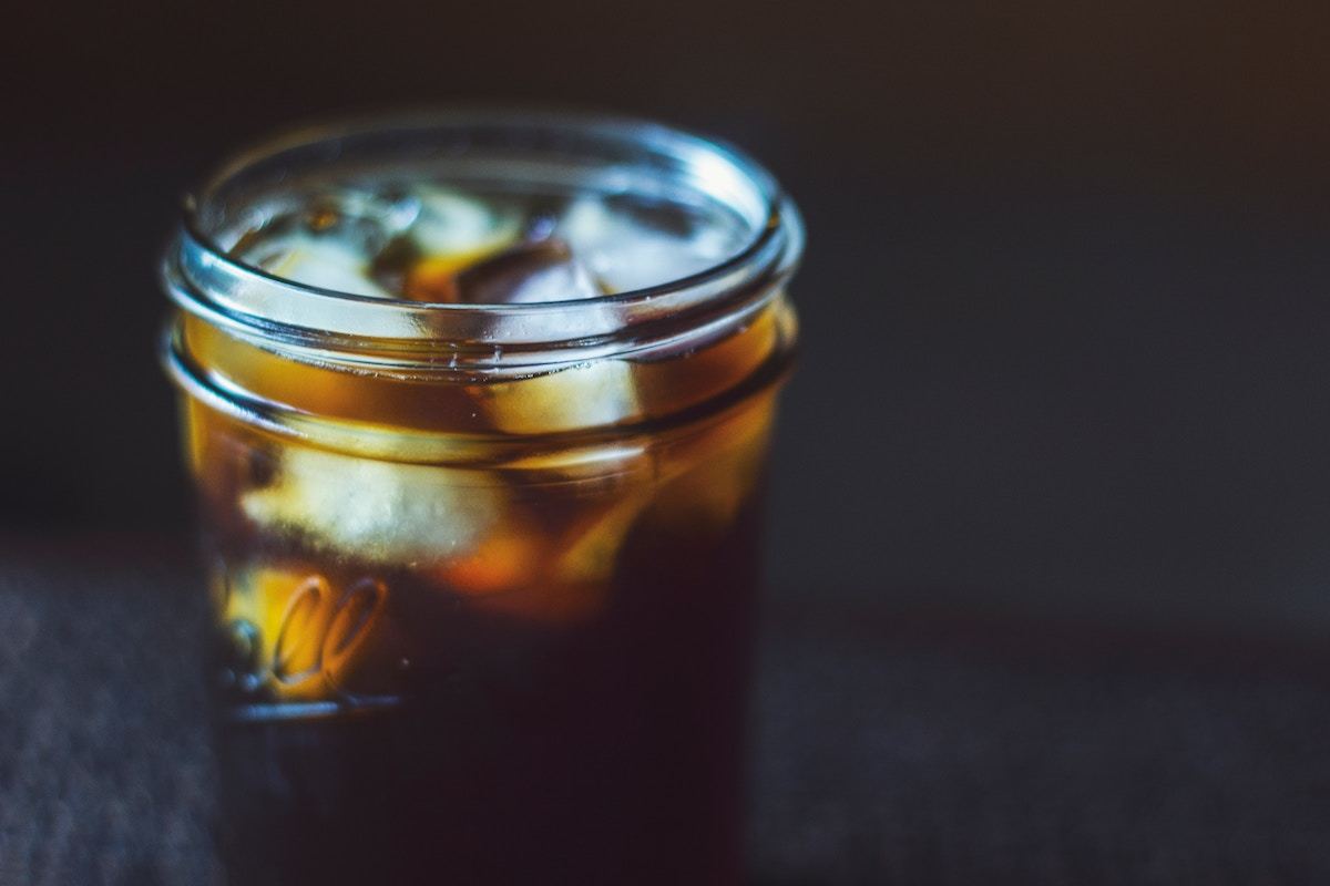 dark image of cold brew in mason jar with ice