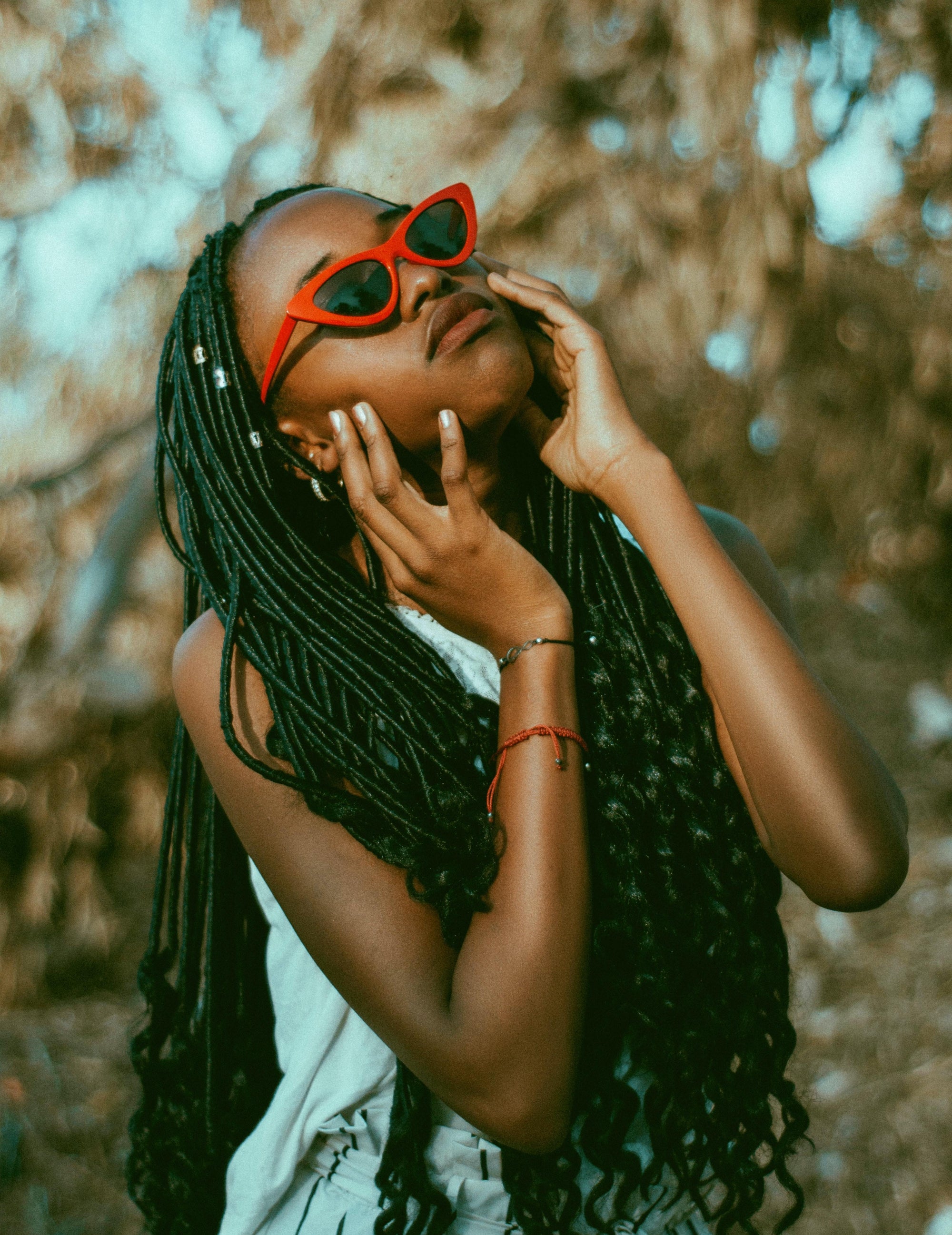 Woman wearing red sunglasses looking up at the sky