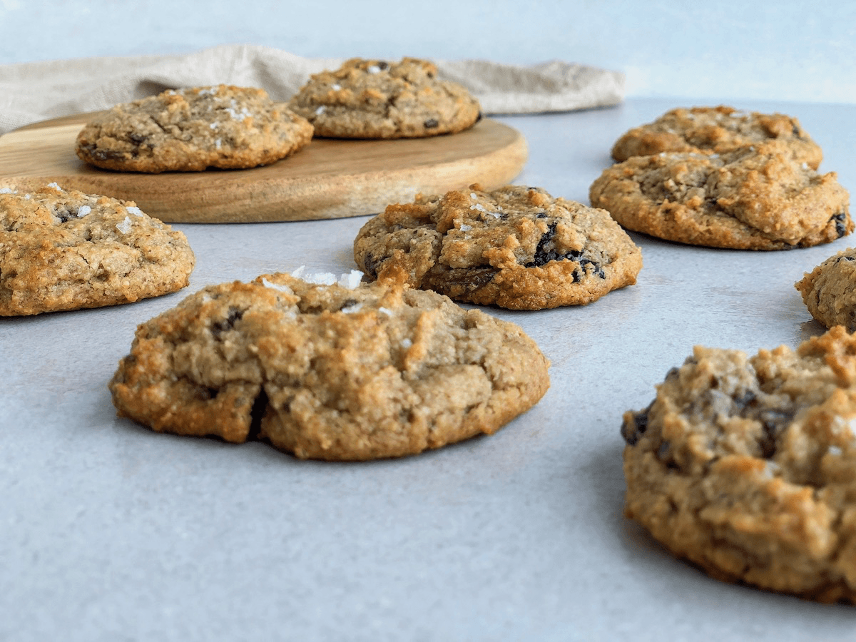 Freshly baked gluten-free chocolate cherry tahini cookies with sea salt sprinkled on top.