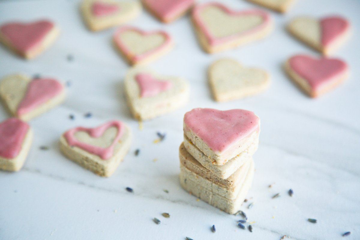 lavender lemon shortbread cut into heart shapes with lavender petals in foreground