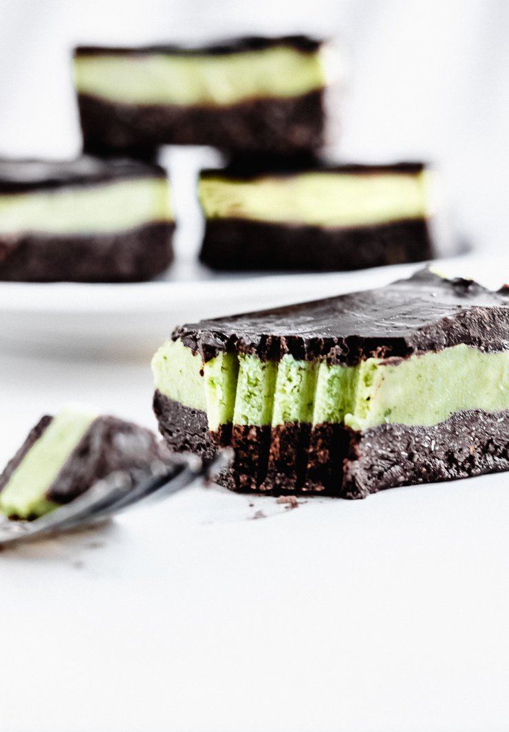close up on mint chocolate avocado bar with fork scratches in it and three more bars in the background