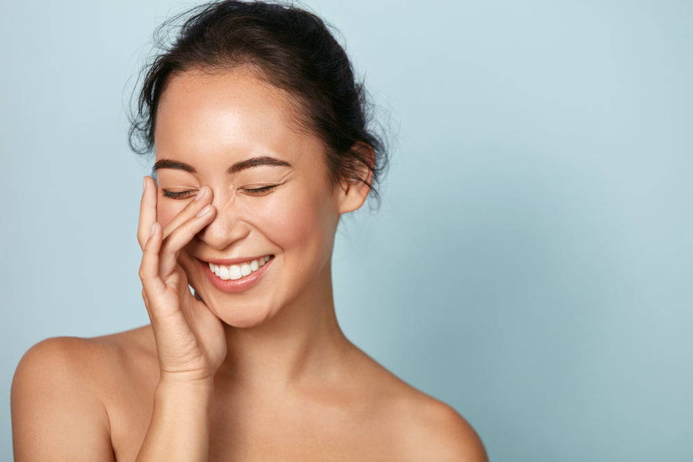 Woman smiling while gently touching face