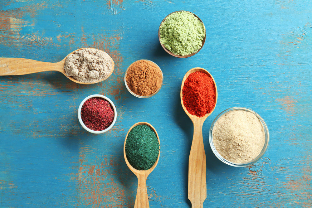 Overhead shot of spoons with colorful superfood powders 