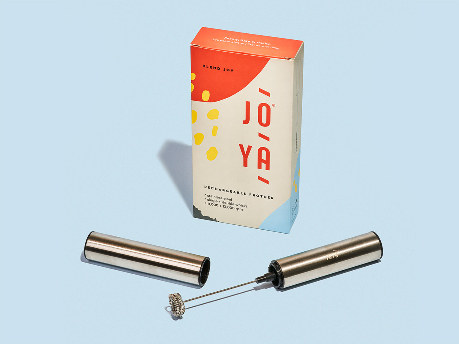 JOYÀ rechargeable handheld frother sitting beside its branded box on a blue background