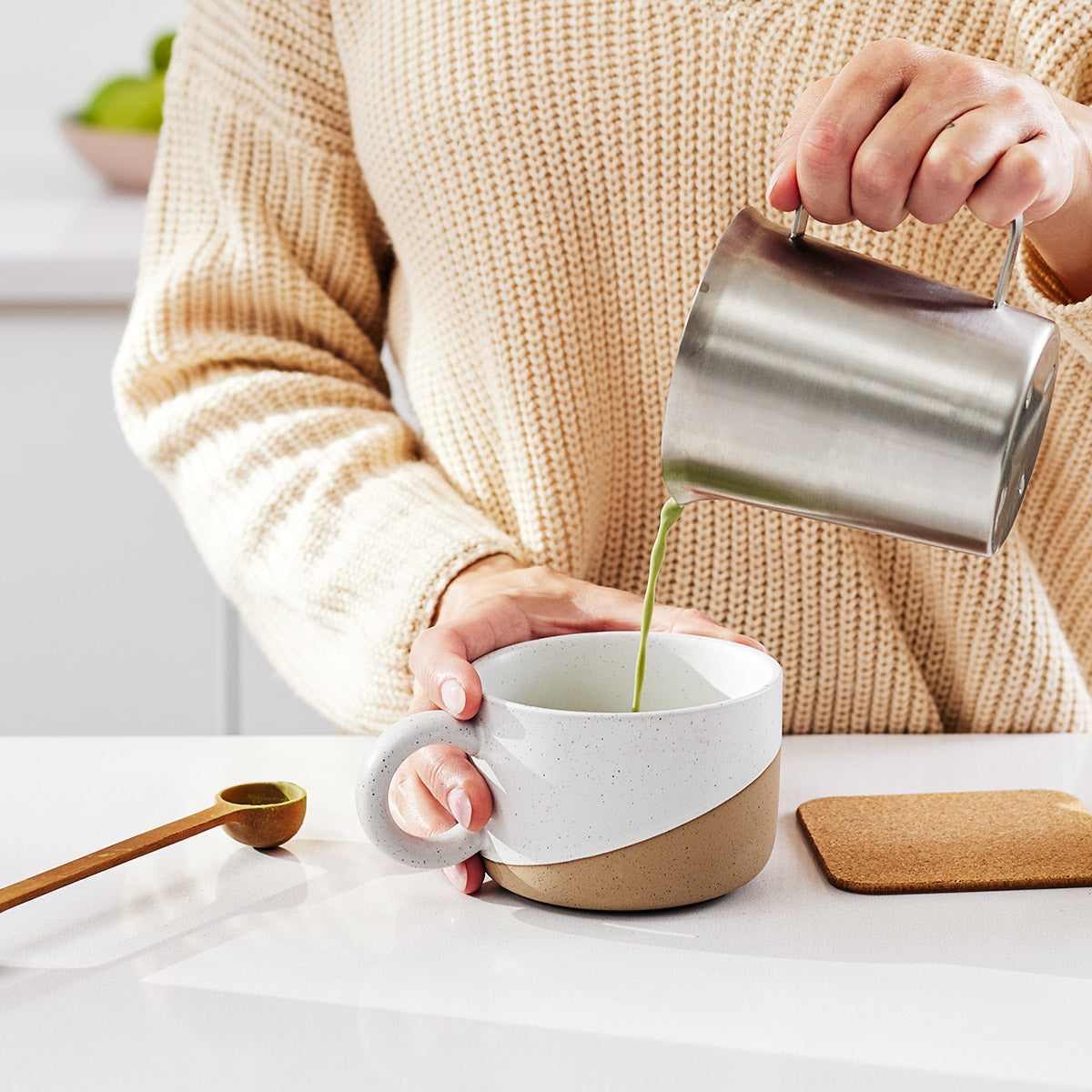 Woman pouring Focus (matcha) Superblend into a mug