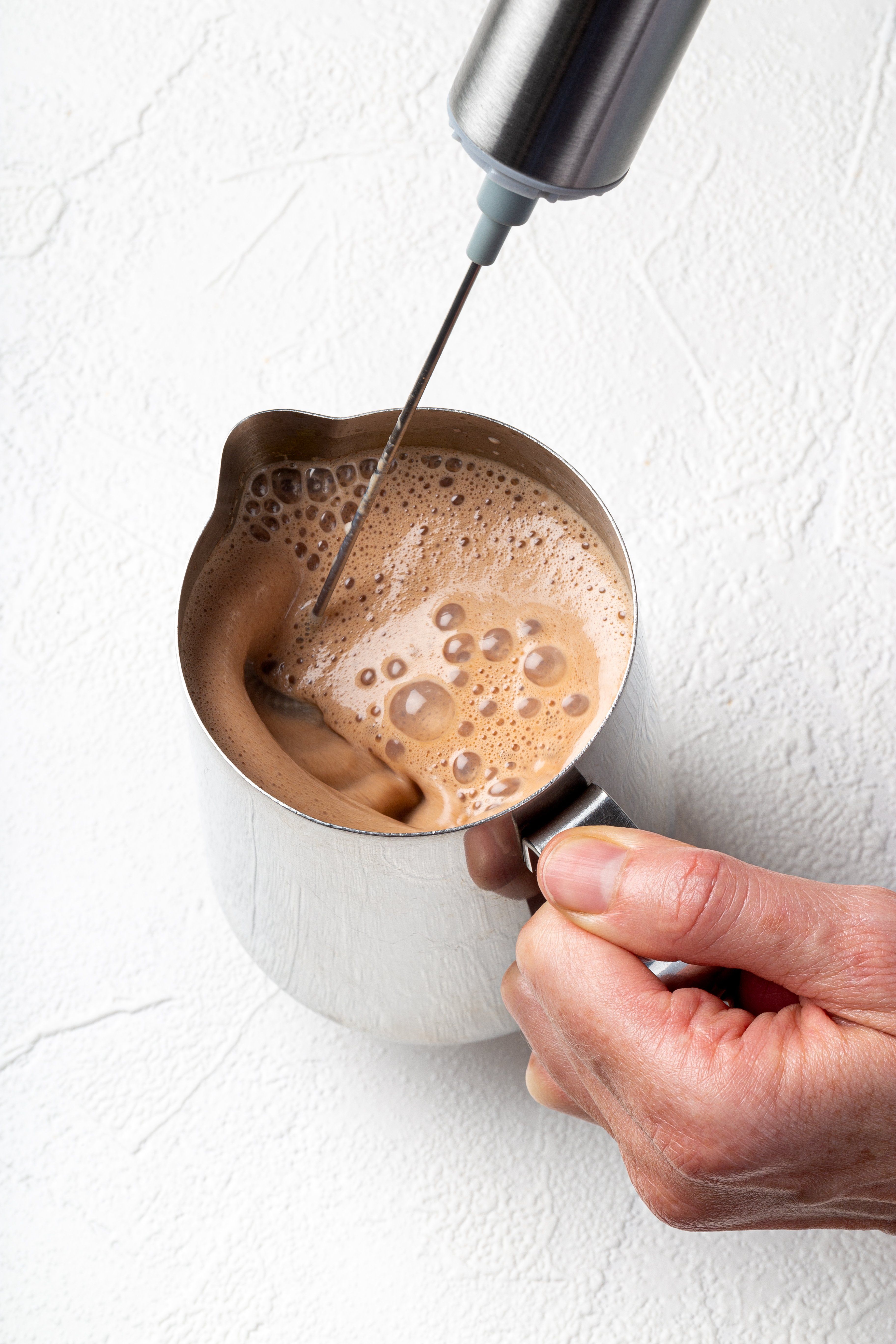 Blending a hot cacao elixir with a JOYÀ handheld rechargeable milk frother and blender.

    